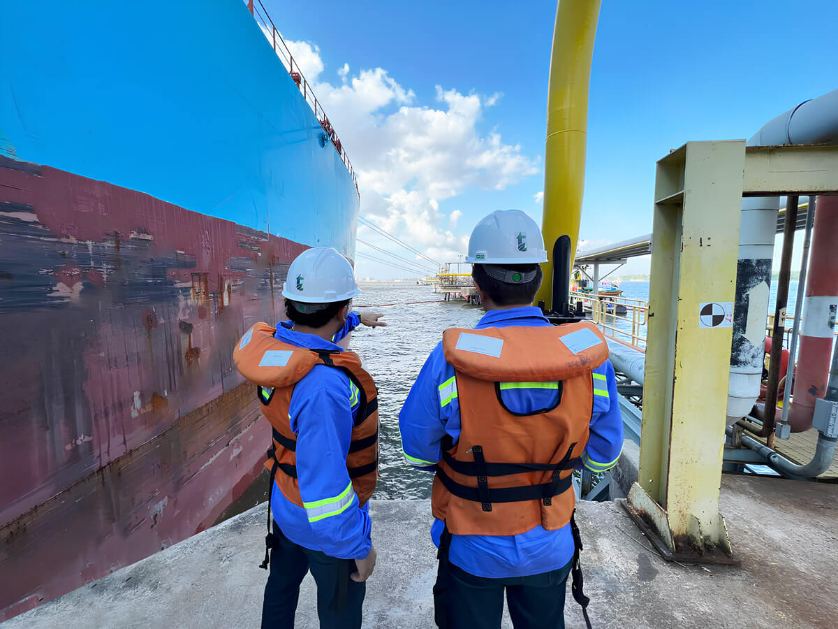 Dois homens no porto marítimo observando um projeto instalado no mar